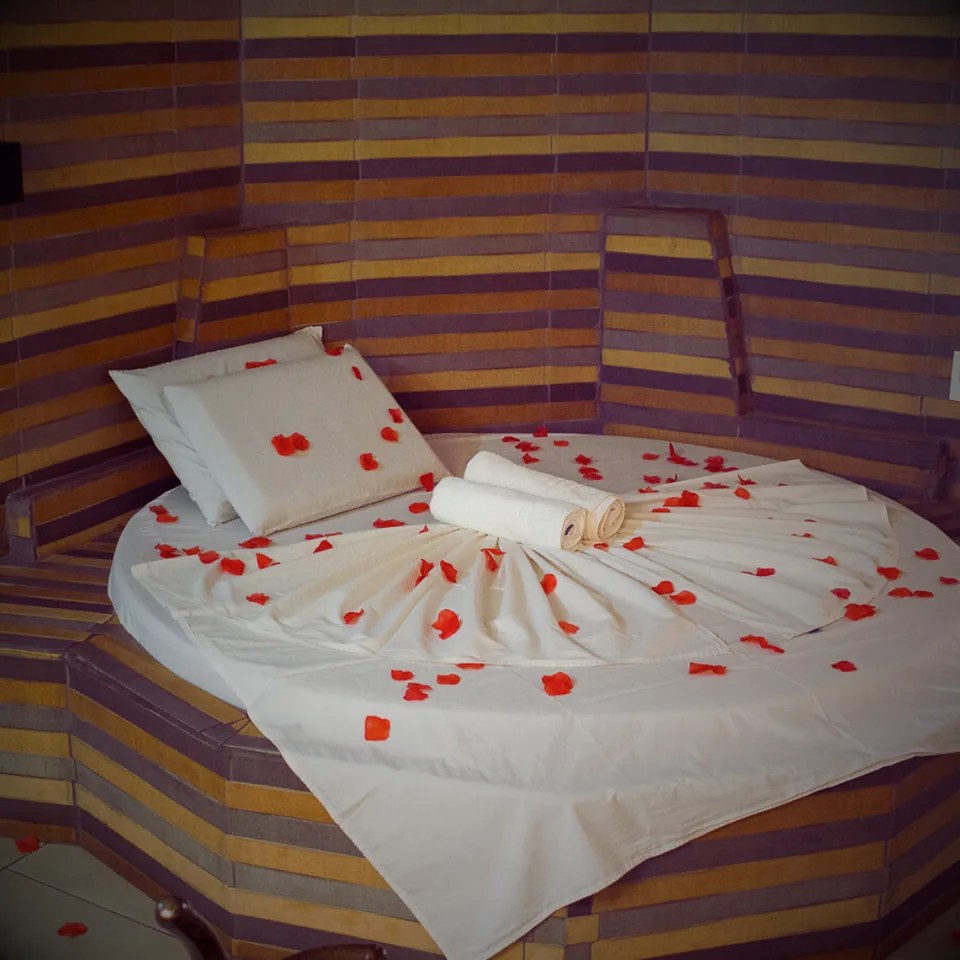 Apartamento Luxo com cama redonda decorada com pétalas de rosa